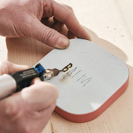 use the dremel versatip to woodburn the wording
