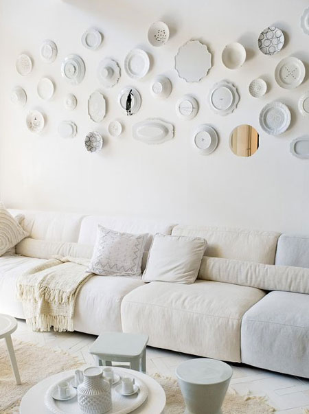 plate collection on wall above long sofa