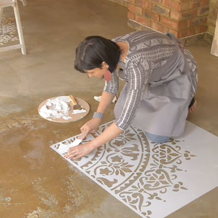 use paint scraper to apply paint mix over the stencil