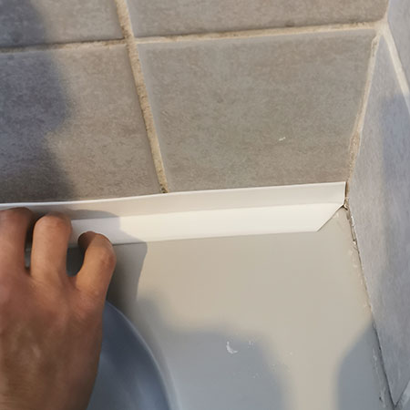 stick sealer tape around edge of bathtub