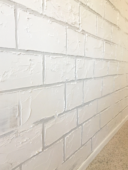white cement faux brick wall