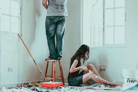 Couple painting a room as one of the DIY home improvement projects